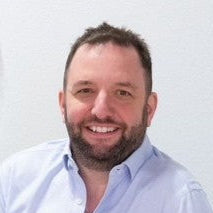Man sitting on a gray sofa in a modern interior setting